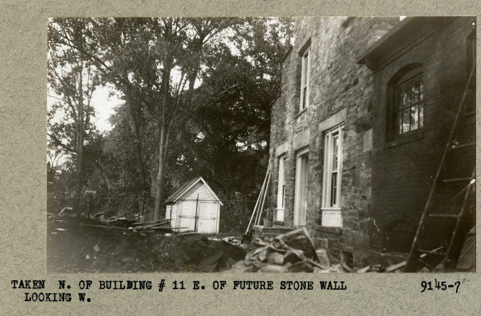 “TAKEN N. OF BUILDING # 11 E. OF FUTURE STONE WALL LOOKING W.” Print 9145-7 — photographed and labeled against a wall not yet built.