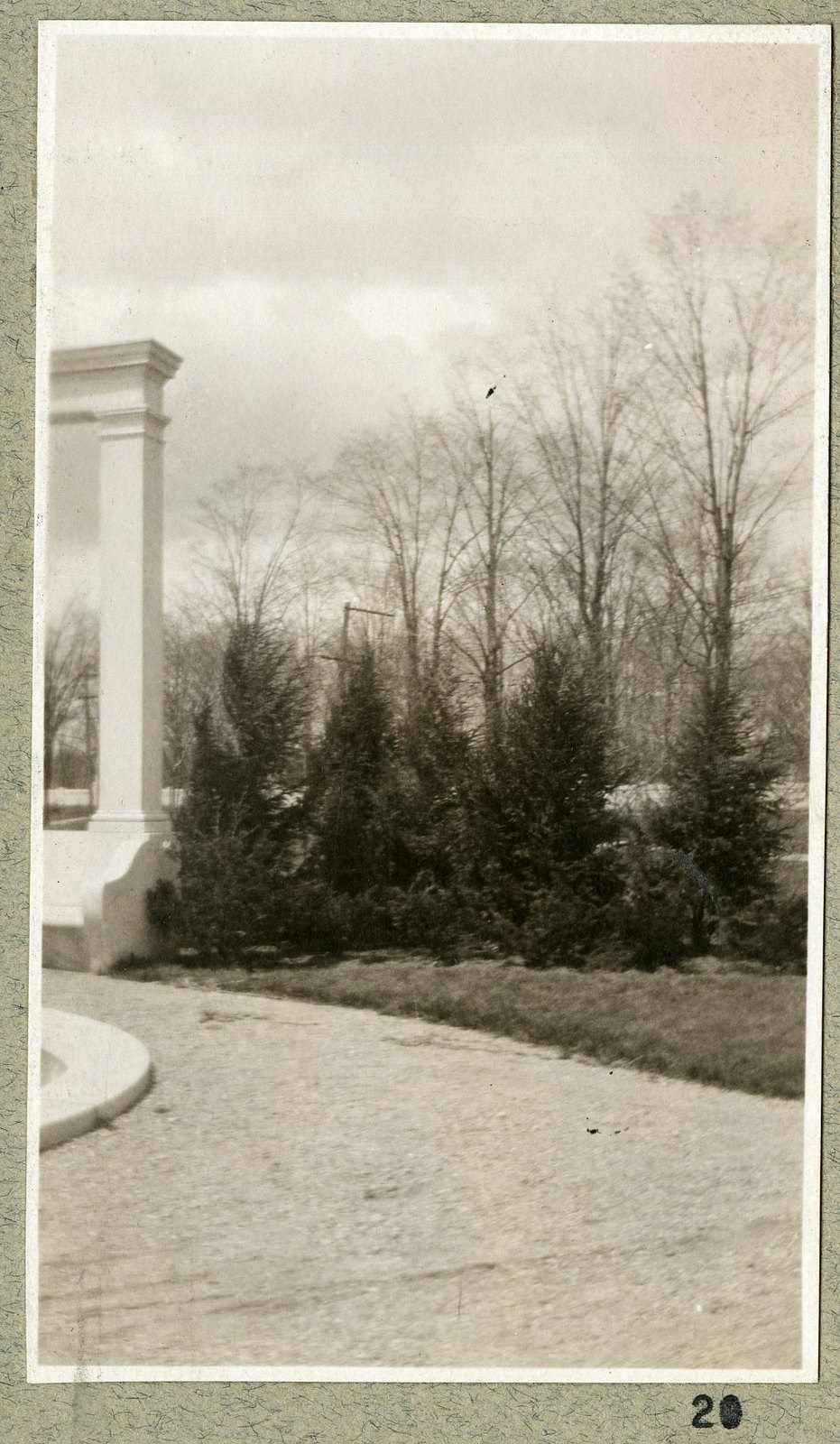 A column, the basin edge and the bare trees beyond. Print 20.
