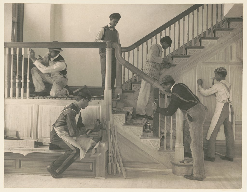Young men fitting a staircase and balustrade in an unfinished house