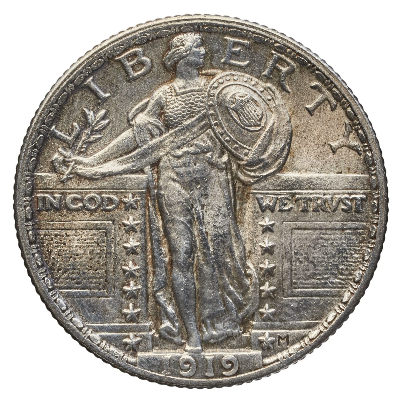 MacNeil’s Standing Liberty quarter, here the Type 2 of 1917 onward, Liberty in a chain-mail shirt. On the 1916 and early 1917 coins her right breast is bare. Why it was changed is disputed: there is no evidence of public outcry, and one historian reads the mail as wartime symbolism — Liberty should face her enemies protected.