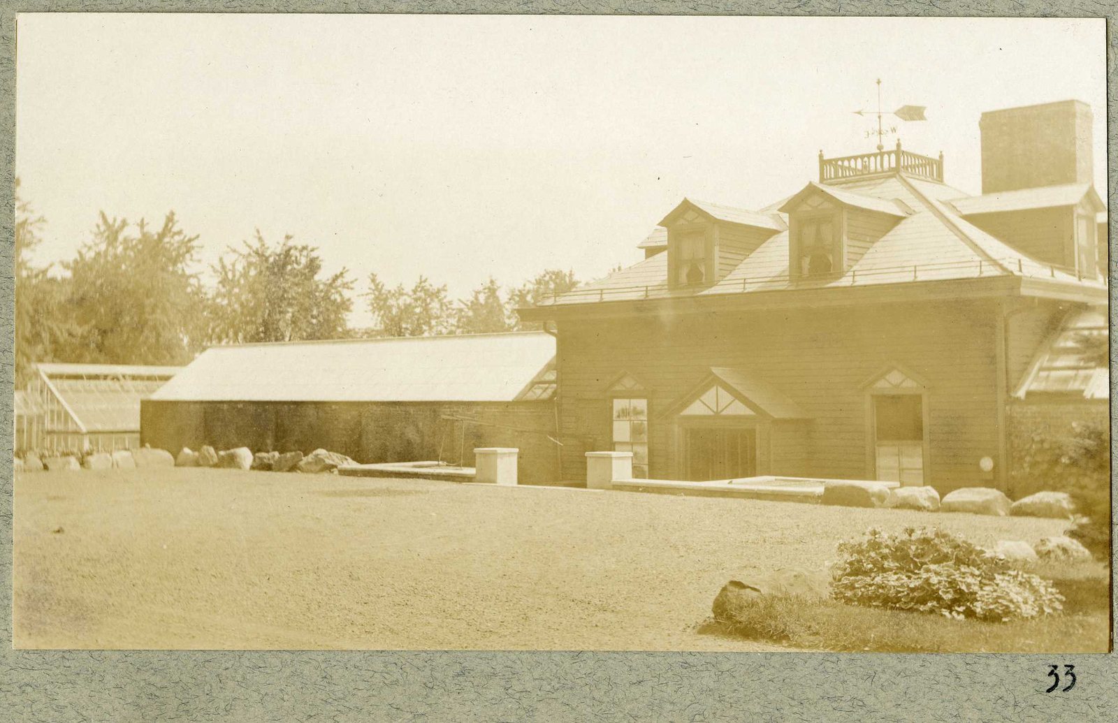 Photograph 33, September 1925. The greenhouse range and a building with a weathervane.