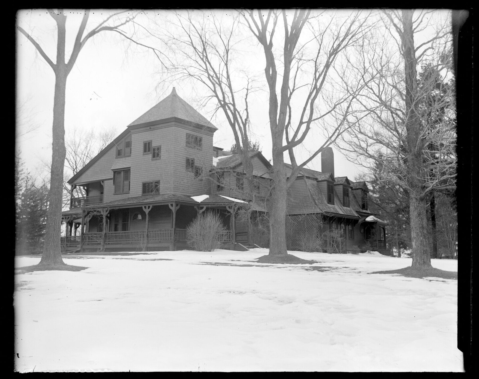 Catalogued as “Highlawn in winter.” A glass negative by Augustus E. Martin, dated by the cataloguer to about 1890–1904. Shingled, with a corner tower, a veranda on sawn brackets and a long service wing — not the house Delano & Aldrich built.