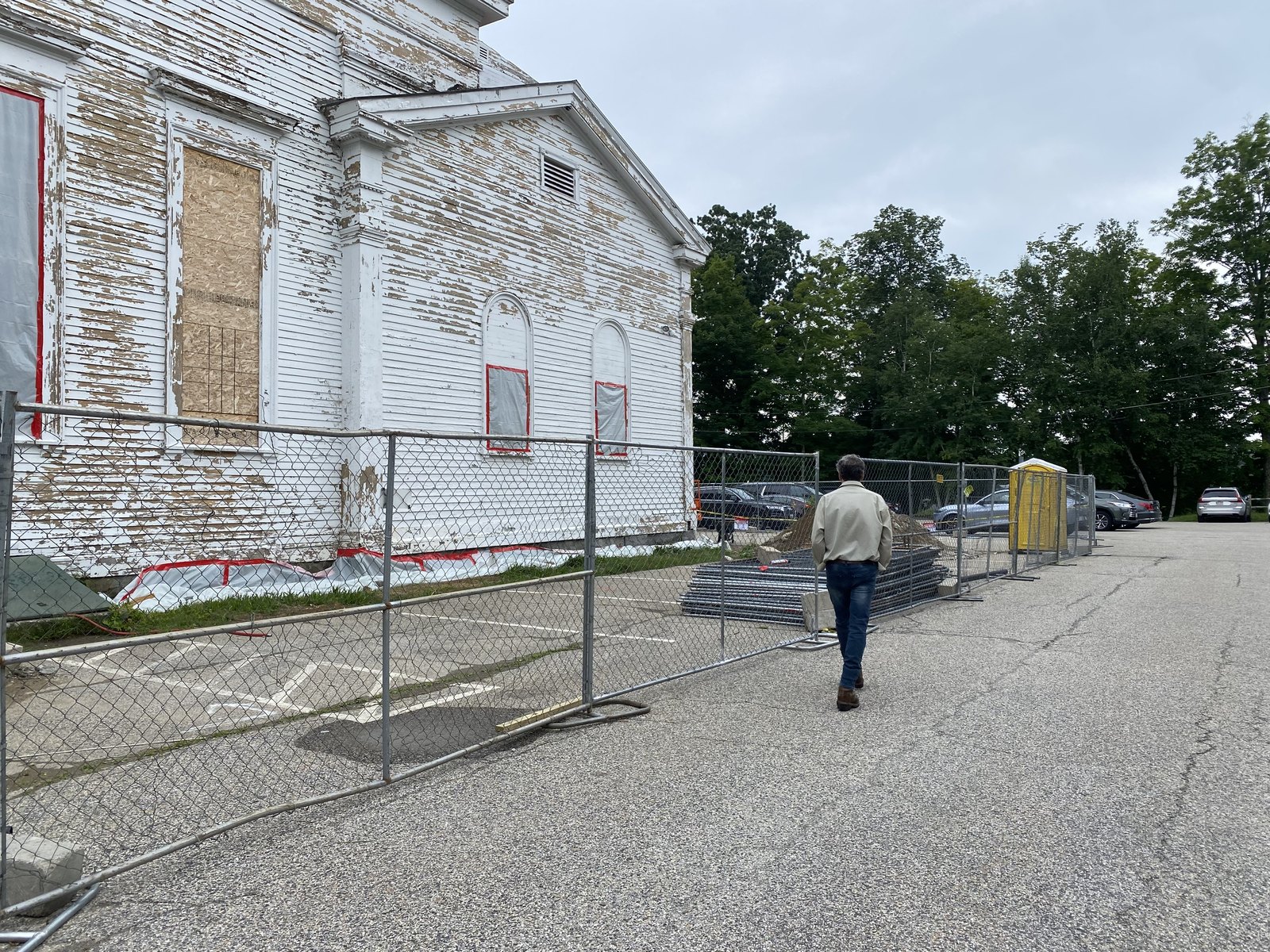 Old Town Hall before the restoration: windows boarded, the clapboard failing, the site fenced.