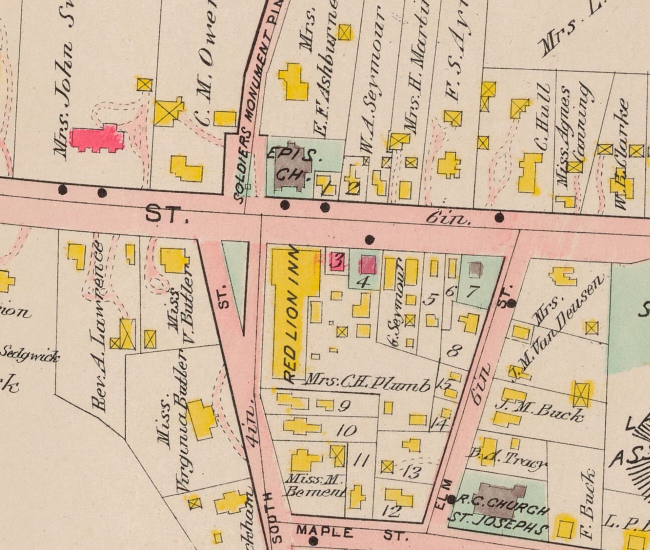 Plate 28, detail. RED LION INN lettered along the long building, drawn in yellow for wood; behind it Mrs. C. H. Plumb’s parcel; at its east corner the Housatonic National Bank, number 3 in the plate’s reference list, drawn in pink for brick. Across Main Street, the Episcopal church in stone and the Soldiers’ Monument.